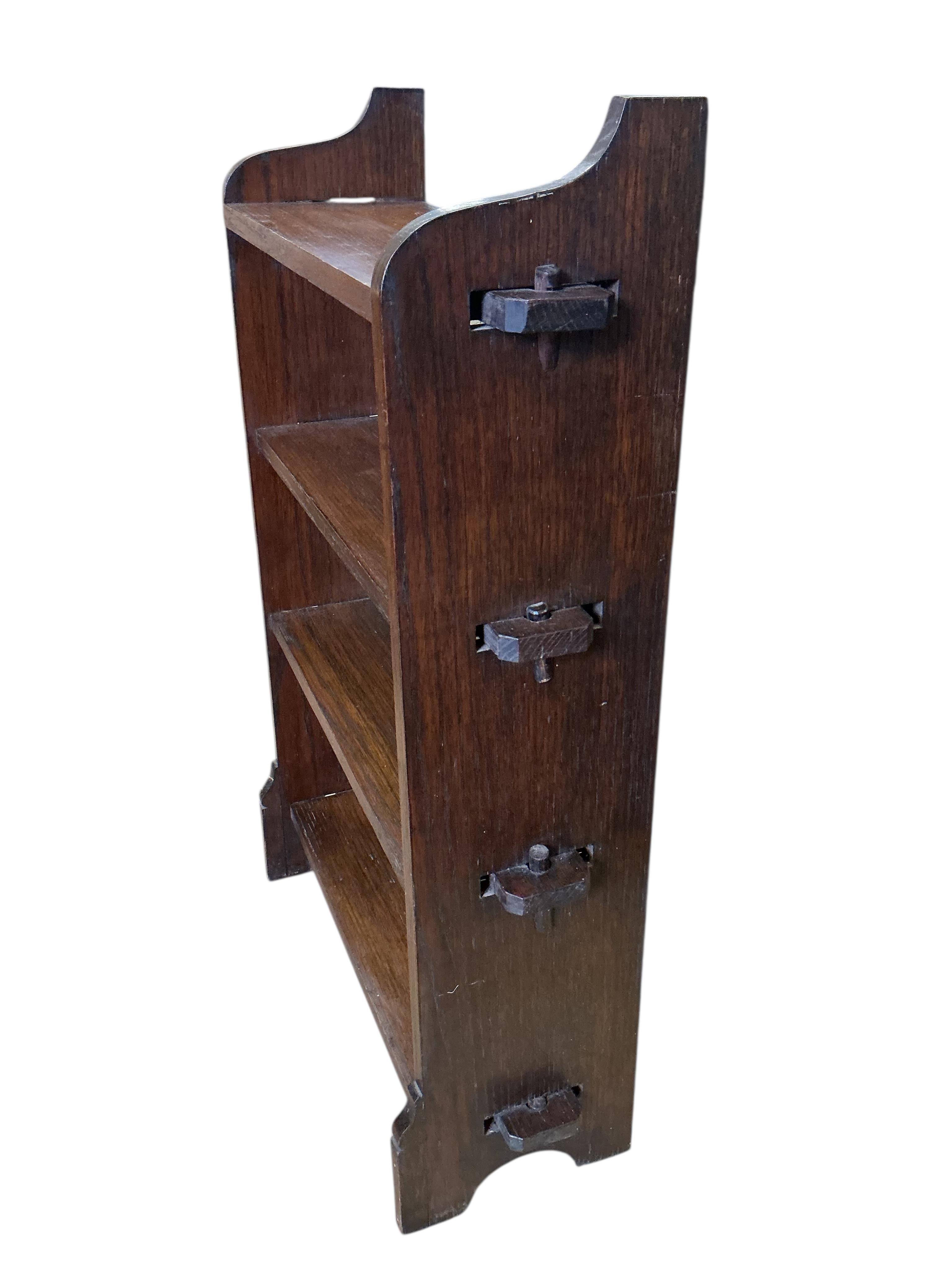 A small Arts & Crafts oak three tier open bookcase, width 60cm, depth 21cm, height 96cm